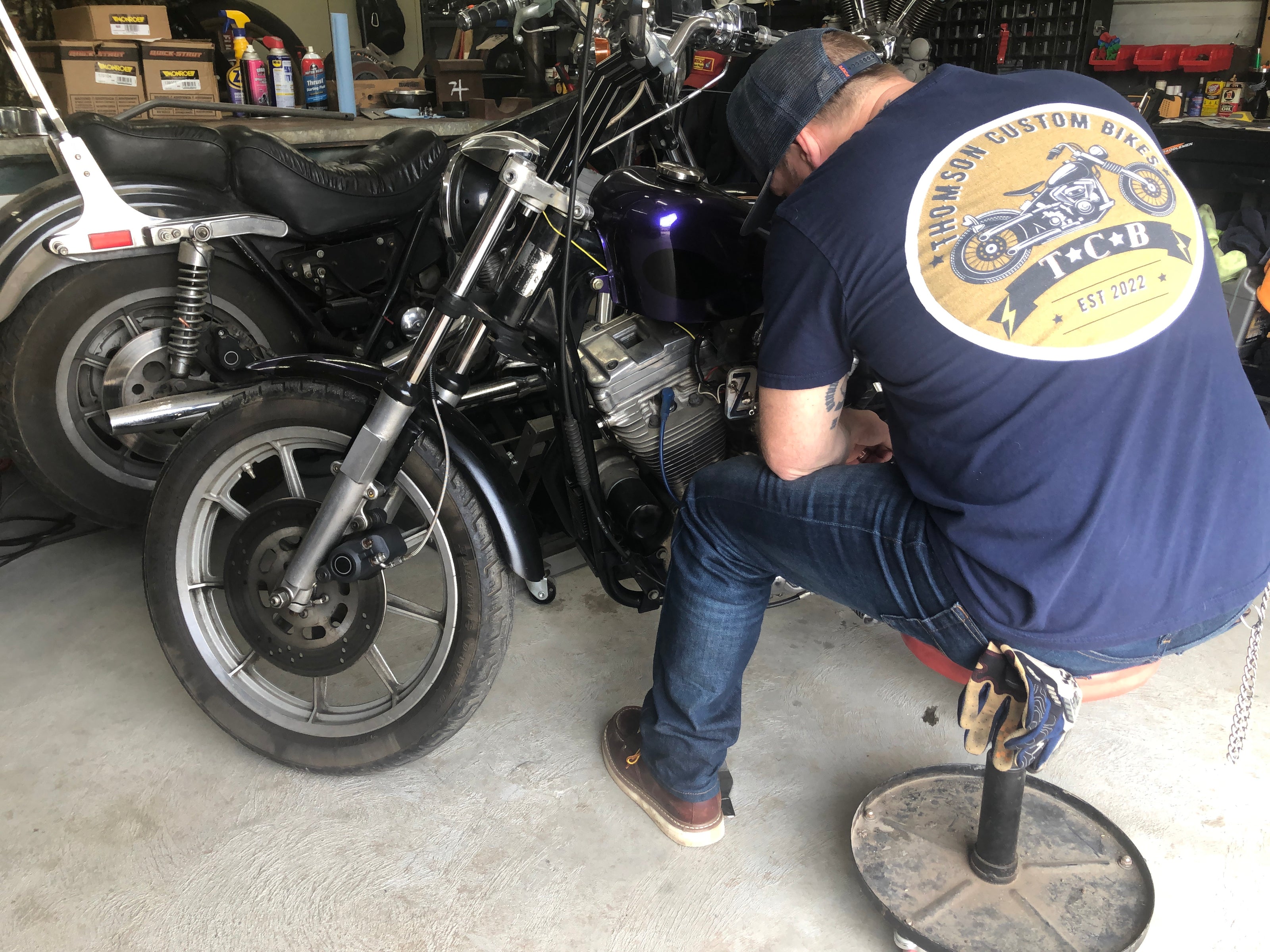 Mechanic working on performance motorcycle wearing vintage tee
