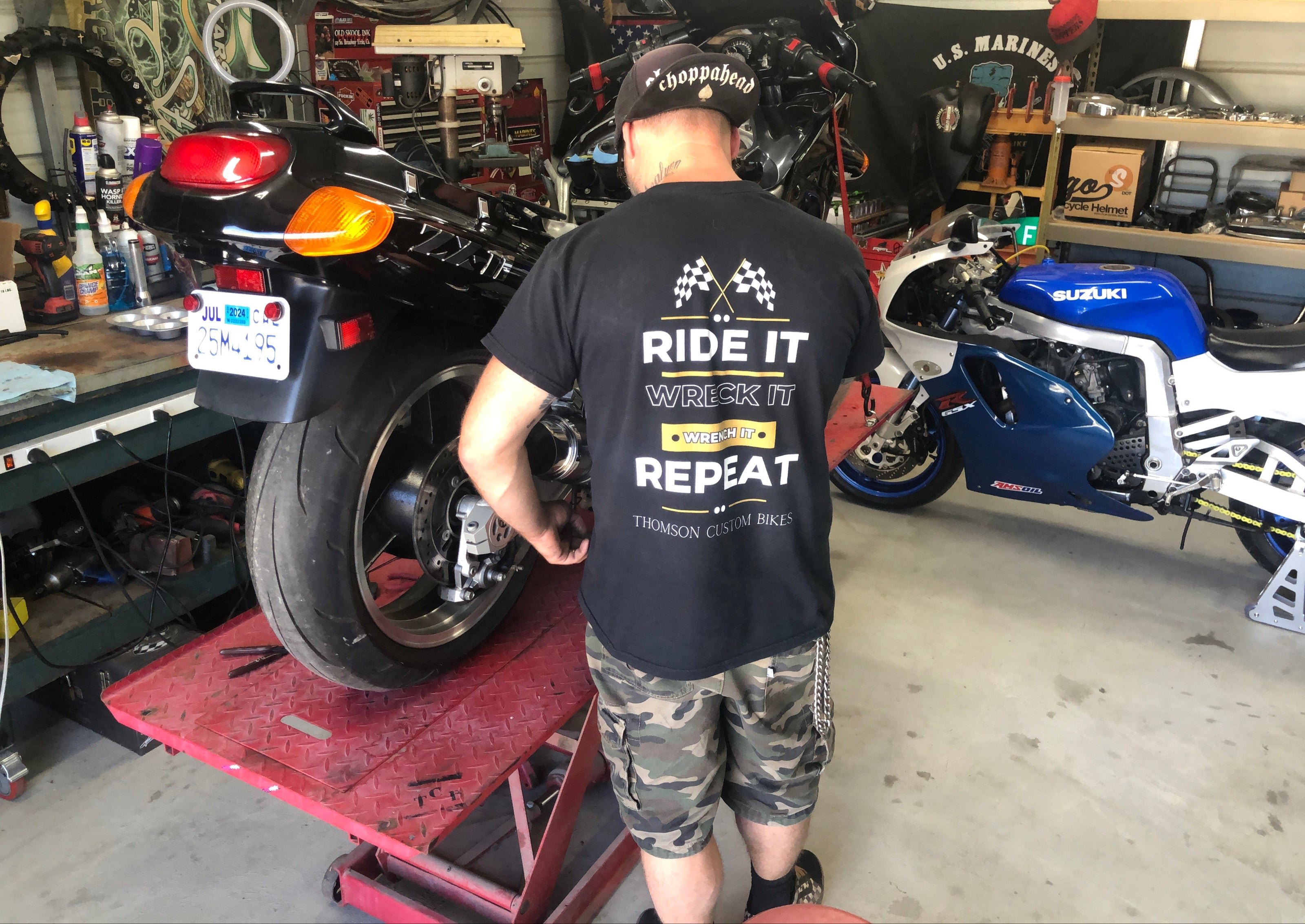 Mechanic working on motorcycle wearing funny tee